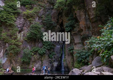 Ribeira Grande, Azoren - 05.09.2019: Touristen stehen in der Nähe des Wasserfalls von „Salto do Cabrito“. Die Insel Sao Miguel auf den Azoren Stockfoto