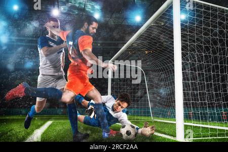 Fußball-Action mit dem Angreifer im Gegensatz zu den Verteidigern, die versuchen, das Tor auf den Torwart zu tun Stockfoto