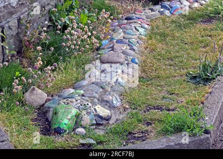 Clevedon, Großbritannien. 14. Juli 2023. An einem feuchten Nachmittag wurde ein Schild mit der Überschrift, dem Clevedon Cobra, entdeckt. Die Schlangenart wurde aus bunten Kieseln und Steinen mit Botschaften wie sicher bleiben, gesund werden, glücklich sein alles in Erinnerung an den Lockdown während der Covid -19 Pandemie. Bildnachweis: Robert Timoney/Alamy Live News Stockfoto