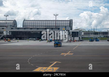 Medellin, Antioquia, Kolumbien - 17. Mai 2021: Mehrere Arbeiter in fluoreszierenden gelben Hemden und Blue Truck Cruising in der Airport Airway Stockfoto