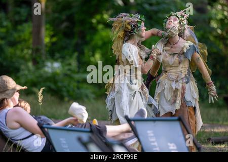 Beelitz, Deutschland. 14. Juli 2023. Abends treten Schauspieler auf dem Gelände des „Tree & Time“-Baumwipfels in Beelitz-Heilstätten auf. An drei Abenden im Juli und August bietet das Abenteuergebiet seinen Gästen Abendprogramme mit Musik, Lichtinstallationen und Vorstellungen. Kredit: Monika Skolimowska/dpa/ZB/dpa/Alamy Live News Stockfoto