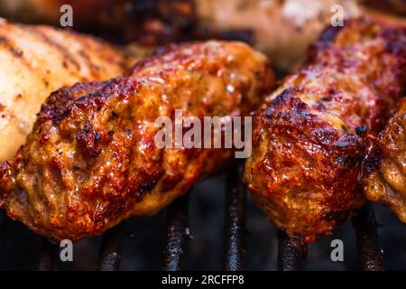 Traditionelle rumänischen Fleischbällchen "mici" auf dem Grill. Schmackhafte Fleischbällchen auf dem Grill, Schweinefleisch auf Holzkohlengrill Stockfoto