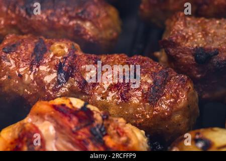 Traditionelle rumänischen Fleischbällchen "mici" auf dem Grill. Schmackhafte Fleischbällchen auf dem Grill, Schweinefleisch auf Holzkohlengrill Stockfoto