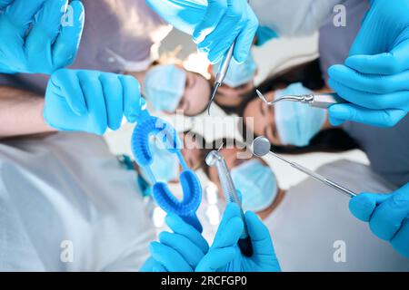 Männer und Frauen mit zahnärztlichen Instrumenten in der Hand Stockfoto
