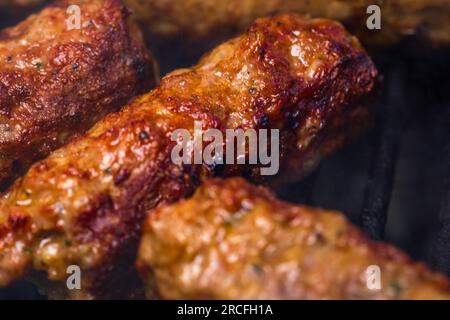 Traditionelle rumänischen Fleischbällchen "mici" auf dem Grill. Schmackhafte Fleischbällchen auf dem Grill, Schweinefleisch auf Holzkohlengrill Stockfoto