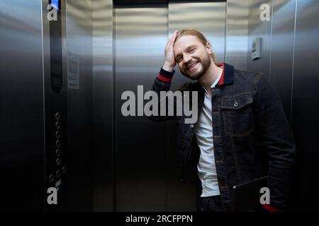 Der Typ in einer Jeansjacke ist im Fahrstuhl Stockfoto