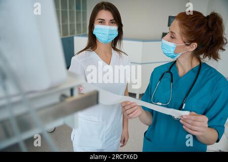Krankenschwester und Arzt diskutieren Analyse auf der Station Stockfoto