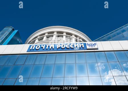 Saransk, Mordowien, Russland, 4.06.2023. Die blaue Fassade des Gebäudes mit der Inschrift Russian Post und einem doppelköpfigen russischen Adler, gegen die Stockfoto