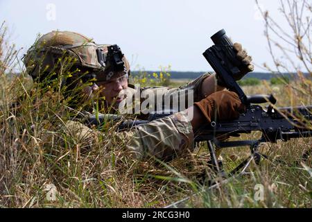 5. Juli 2023 - Bemowo Piskie, Polen - (von links) USA Army SPC. Semaj Girtmon und SPC. Jaycob Plasek mit Charlie Company, 1. Bataillon, 9. Kavallerie-Regiment, 1. Kavallerie-Division, unterstützt die 4. Infanterie-Division, lädt ein M249-kg-Leichtmaschinengewehr während einer Feuerübung auf einem Gelände im Bemowo Piskie-Trainingsbereich, Juli 5. Die 4. Inf. Divs Mission in Europa besteht darin, sich an multinationalen Schulungen und Übungen auf dem ganzen Kontinent zu beteiligen und mit NATO-Verbündeten und regionalen Sicherheitspartnern zusammenzuarbeiten, um Kampfkräfte für V Corps, Amerikas vorwärtsgebrachtes Korps in Euro, zu liefern Stockfoto