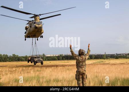 Ungarn. 23. Juni 2023. Ein Soldat, der der 1. Staffel, dem 32. Kavallerie-Regiment, dem 1. Brigaden-Kampfteam, der 101. Luftwaffendivision zugeteilt ist, leitet einen CH-47 Chinook, der der 3. Kampfluftfahrtbrigade zugeteilt wurde und die 4. Infanterie-Division während des Sling-Load-Trainings in Camp Croft, Ungarn, 23. Juni 2023, unterstützt. Kredit: USA Army/ZUMA Press Wire/ZUMAPRESS.com/Alamy Live News Stockfoto