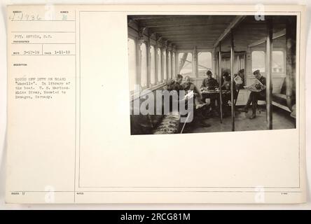 Gefreiter Antrim der USA Marines machen an Bord der „Mosel“ am Rhein eine Pause, während sie von Neuwied nach Remagen reisen. Das Foto wurde am 11. Januar 1919 aufgenommen und zeigt die Bibliothek an Bord des Bootes. Dieses Bild ist Teil der Sammlung 111-SC-44936, wobei der Fotograf als RECO aufgenommen wurde und das Foto am 27. März 1919 einging. Stockfoto