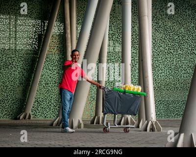 Medellin, Antioquia, Kolumbien - 3 2022. Juni: Kolumbianischer Mann, der Mangos in einem Wagen verkauft und der Kamera zuwinkt Stockfoto