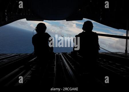 Royal Australian Air Force Corporal Charlotte Roe, ein C-17 Globemaster III Loadmaster, der der 36. Staffel RAAF in Base Amberley, Australien, links und USA zugewiesen wurde Air Force Master Sergeant Jason Livingston, ein C-17-Loadmaster, der der 16. Airlift-Geschwader in Joint Base Charleston, SC, zugewiesen wurde C-17 vom 62. Luftschleusenflügel in der Joint Base LewisCMcChord, Washington, fliegt hinter einem RAAF C-17 von Nr. 36 SQN über dem Commonwealth der Nördlichen Marianen während des Trainings Mobility Guardian 23 vom 12. Juli 2023. MG23 ist eine Gelegenheit, gemeinsam mit unseren Alliierten und Partnern Dämonen zu trainieren Stockfoto