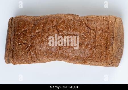 Frisch geschnittenes braunes Brot über dem oberen Rand, isoliert auf weißem Studiohintergrund Stockfoto