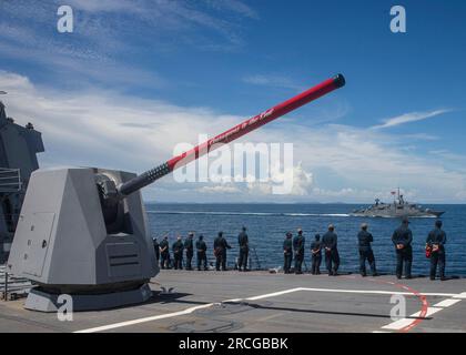 GOLF VON THAILAND (29. Juni 2023) Seeleute an Bord der Arleigh Burke-Klasse-Guided-Missile Destroyer USS Rafael Peralta (DDG 115) bewachen die Schienen, um dem Royal Thai Navy Kriegsschiff HTMS Rattanakosin (FSGM 441) während einer Durchgangsübung Respekt zu zollen und Ehre zu erweisen. Rafael Peralta ist der Task Force 71/Destroyer Squadron (DESRON) 15, der größten nach vorn verlegten DESRON der Marine, und der Hauptstreitkraft der US-7.-Flotte zugewiesen. (USA Marinefoto von Mass Communication Specialist 2. Class Colby A. Mothershead) Stockfoto