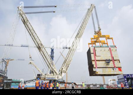 YANTAI, CHINA - 14. JULI 2023 - Ein großer Kran hebt das CA20-Modul in die Atominsel von Block 4 im Kernkraftwerk Shandong Haiyang in Y Stockfoto