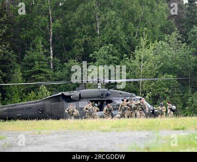 USA Soldaten, die am besten Krieger-Wettbewerb (BWC) der Army National Guard (ARNG) teilnehmen, verlassen einen UH-60L Black Hawk Helikopter, der Einem Unternehmen zugewiesen ist, 1. Bataillon, 168. Luftfahrtregiment, Alaska Nationalgarde auf der gemeinsamen Basis Elmendorf-Richardson, Alaska 12. Juli 2023. Die ARNG BWC testet die Anpassungsfähigkeit und Letalität unserer Streitkräfte, da unsere Bürgersoldaten der Nationalgarde weiterhin bereit und widerstandsfähig sind, die Herausforderungen der Nation zu bewältigen. (USA Air National Guard (Foto) von Master Sgt. David Eichaker) Stockfoto