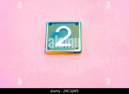 Zwei, 2, blaue Zahl auf rosa Hintergrund. Stockfoto
