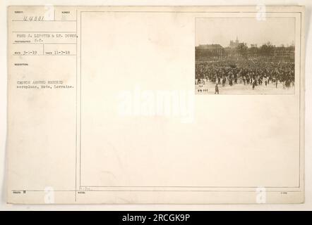 Menschenmassen versammeln sich um ein zerstörtes Flugzeug in Metz, Lothringen. Das Foto wurde am 7. November 1918 aufgenommen. Es wurde von Fred J. Lipster und LT. Downs herausgegeben und ist Teil der Serie 44001. Das Bild zeigt die Folgen militärischer Aktivitäten während des Ersten Weltkriegs in Metz. Stockfoto