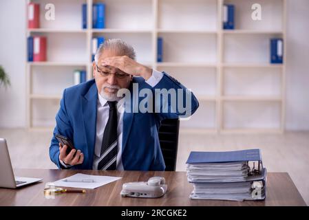Alter Geschäftsmann Angestellte, der im Büro arbeitet Stockfoto