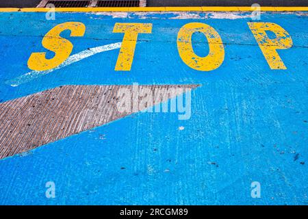 Gelbes Wort AUF blauem Hintergrund VOR dem Eingang zu einer städtischen Tiefgarage. Stockfoto