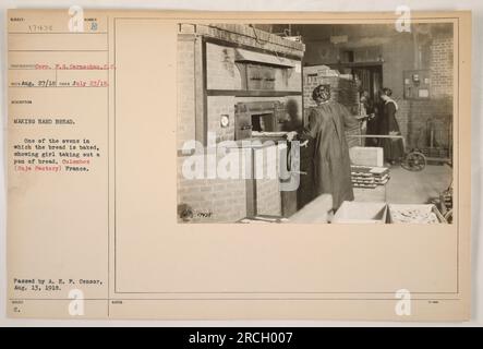 Ein Mädchen wird dabei gesehen, wie es eine Pfanne Brot aus einem der Backöfen in der Colombes (Soja Factory) in Frankreich herausnimmt. Dieses Foto, aufgenommen von Corp. F.G. Carnochan am 23. Juli 1918 zeigt den Prozess der Herstellung von hartem Brot während des Ersten Weltkriegs. Das Bild wurde am 13. August 1918 vom A.E.F.-Zensor genehmigt. Stockfoto