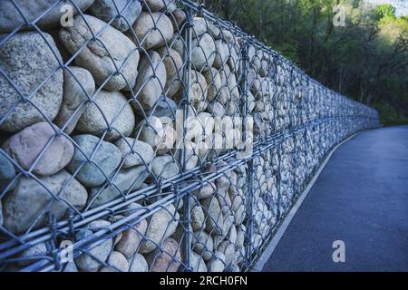 Steinzaun mit Eisenstäben am Bürgersteig. Design im Park Stockfoto