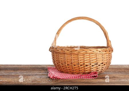 Picknickkorb aus Korb und Serviette auf Holztisch vor weißem Hintergrund Stockfoto