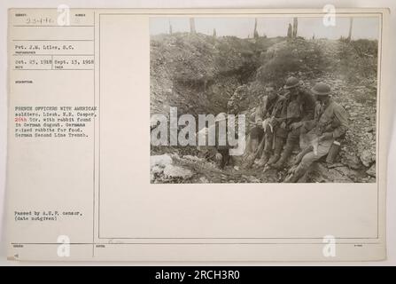 Leutnant N.R. Cooper von der 26. Division ist mit einem Kaninchen in einem deutschen Dugout abgebildet. Deutsche Soldaten züchteten in ihrem Zweitliniengraben Kaninchen für Nahrung. Dieses Foto wurde von Pvt. J.M. gemacht Liles am 13. September 1918. Aufgenommen in Frankreich, zeigt es die Kameradschaft zwischen amerikanischen und französischen Offizieren während des Ersten Weltkriegs. Stockfoto