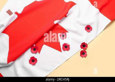 Mohnblumen mit kanadischer Flagge auf gelbem Hintergrund. Gedenktag Stockfoto