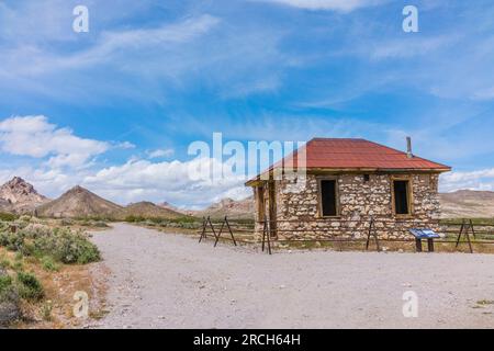 Das alte Felsenhaus in der Geisterstadt Rhyolite soll entweder ein Bergarbeiterhaus, ein Bordell oder ein Büro für die nahe gelegenen zwei Eisenbahnlinien sein. Stockfoto