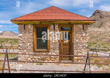 Das alte Felsenhaus in der Geisterstadt Rhyolite soll entweder ein Bergarbeiterhaus, ein Bordell oder ein Büro für die nahe gelegenen zwei Eisenbahnlinien sein. Stockfoto