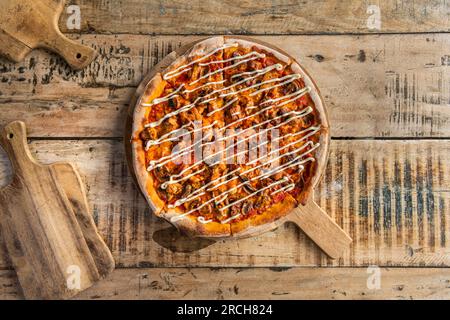 Köstliche Pizza mit Käse und Tomatensauce auf Holzbrett, Blick von oben Stockfoto