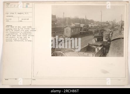 Ein Foto, das am 24. Dezember 1918 von Sergeant John P. Musler aufgenommen wurde, zeigt den Eisenbahnführer des 3. Armeekorps im Ersten Weltkrieg. Das Bild zeigt zahlreiche 3-Tonnen-Lkw, die mit Armeerationen für den Transport zu verschiedenen Organisationen beladen werden. Im Hintergrund ist ein Lager zu sehen, in dem die Rationen gelagert werden. Auf der linken Seite befindet sich ein Bahnhofsschild mit der Bezeichnung Neuwied, Deutschland, speziell Heddesdorf. Die Referenznummer des Fotos lautet 44322. Stockfoto