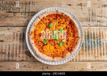 Köstliche Pizza mit Käse und Tomatensauce auf einem Holztisch, Blick von oben Stockfoto