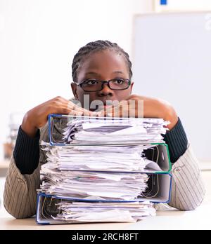 Die schwarze Mitarbeiterin, die mit übermäßiger Arbeit unzufrieden ist Stockfoto