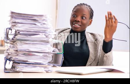 Die schwarze Mitarbeiterin, die mit übermäßiger Arbeit unzufrieden ist Stockfoto