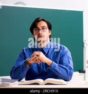 Der junge Lehrer vor dem Schwarzen Brett Stockfoto