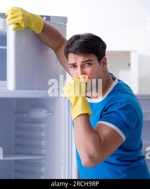 Der Mann Reinigung Kühlschrank im hygienekonzept Stockfoto