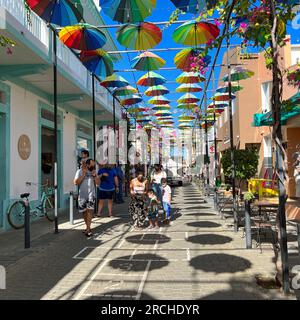 Puerto Plata, DR – 10. Januar 2022: Menschen spielen und geselligen sich auf der Umbrella Street in Puerto Plata, DR. Stockfoto