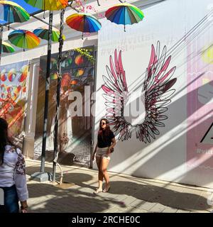 Puerto Plata, DR – 10. Januar 2022: Menschen spielen und geselligen sich auf der Umbrella Street in Puerto Plata, DR. Stockfoto