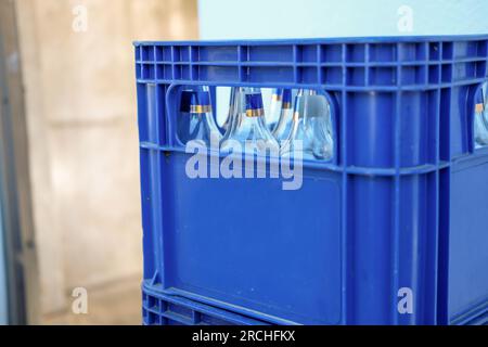 Blaue Bierkiste aus Kunststoff mit leeren Flaschen Stockfoto