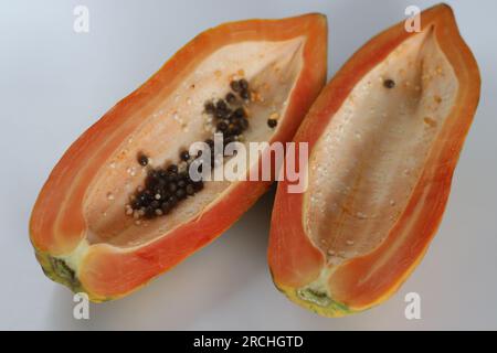 Reife und verzehrfertige Papayaschneiden. Lange Scheiben reifer Papaya mit weniger Samen im Inneren. Sie hat orangisch-gelbe Haut und ist weich zu berühren. S Stockfoto