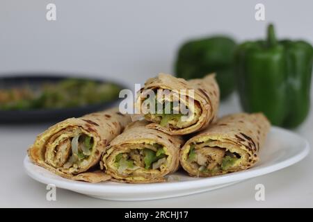 Hühnchen- und Eierpackung oder Hühnerbrötchen mit Eiern. Gebratene Paprika und Hähnchen umrühren, verpackt in Vollkornbrot und Eieromelett. Erschossen Stockfoto