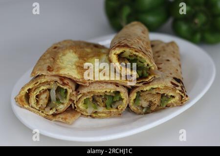 Hühnchen- und Eierpackung oder Hühnerbrötchen mit Eiern. Gebratene Paprika und Hähnchen umrühren, verpackt in Vollkornbrot und Eieromelett. Erschossen Stockfoto