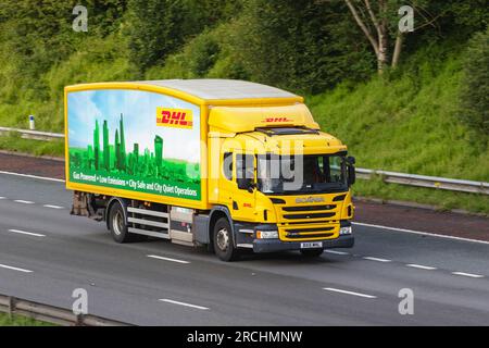 Gasbetriebener, emissionsarmer, City Safe DHL-Liefermann mit gelbem 2023 SCANIA P280, zweiachsiger Lkw, Fahrt auf der Autobahn M6 im Großraum Manchester, Großbritannien Stockfoto