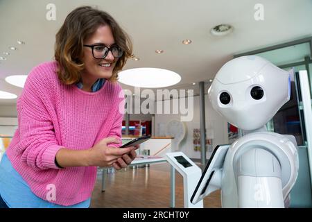 Eine Frau kommuniziert mit einem Roboterberater. Stockfoto