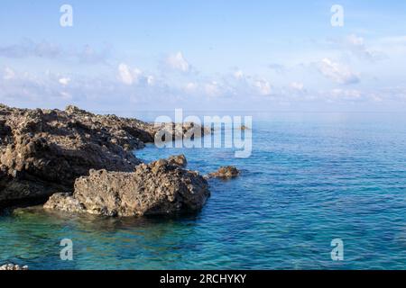 Die Wasseroberfläche eines klaren blauen Ozeans an einer fantastischen tropischen Küste. Wellen auf der Oberfläche des Ozeans. Stockfoto