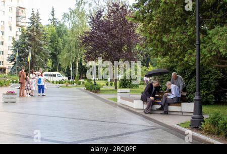 Zhytomyr, Ukraine, 28. Juni 2023: Three Senioren Men are play Chess. Senior man plant seinen nächsten Schachzug. Schach im Park spielen. Stockfoto