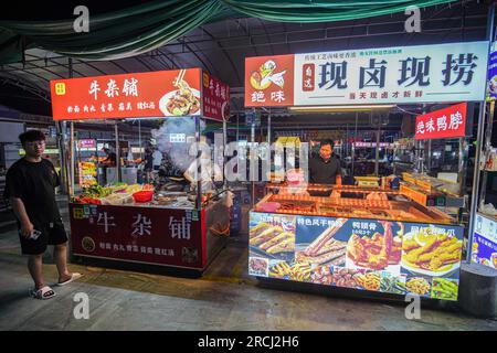 Guangzhou, China. 12. Juli 2023. Die Leute kochen und verkaufen Essen auf einem Nachtmarkt. (Foto: Michael Ho Wai Lee/SOPA Images/Sipa USA) Guthaben: SIPA USA/Alamy Live News Stockfoto